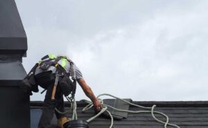 Rainwater flows from a shingled roof into clean gutters and downspouts beside a residential house.